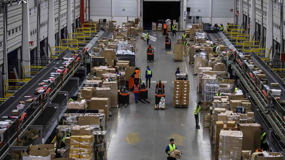 Mozos de almacén organizando paquetes en un centro logístico de San Fernando de Henares (Madrid) para una empresa de paquetería.