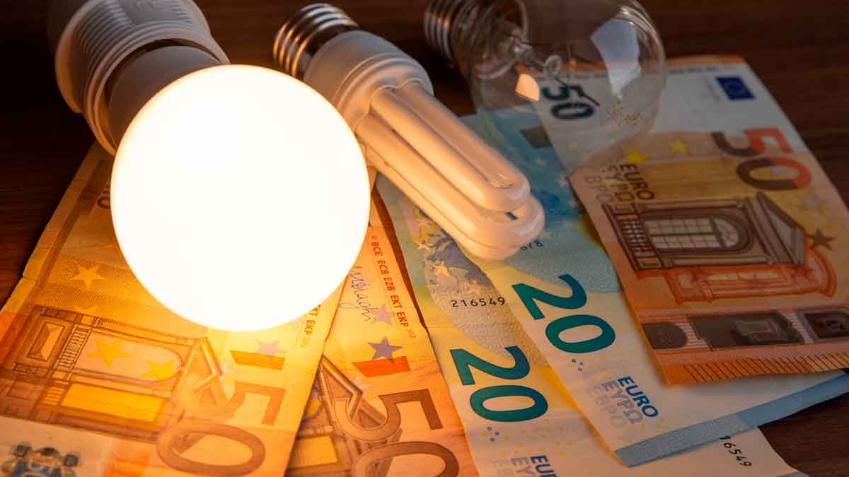 Evolución y subida del precio de la luz en 2025 en Madrid, bombilla iluminada sobre billetes de euro.