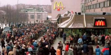 Clientes haciendo largas colas frente a McDonald’s para probar la nueva McExtreme Tutti Pepperoni en un día de invierno.