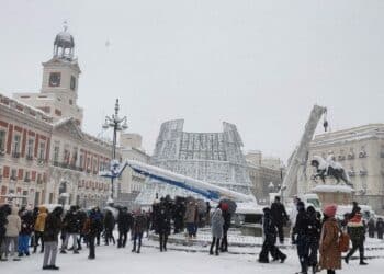 Puerta del Sol nevada en Madrid con varias personas observando el paisaje invernal