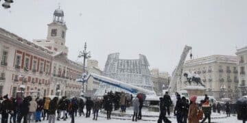 Puerta del Sol nevada en Madrid con varias personas observando el paisaje invernal