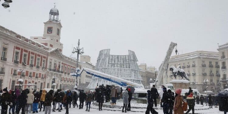 Puerta del Sol nevada en Madrid con varias personas observando el paisaje invernal