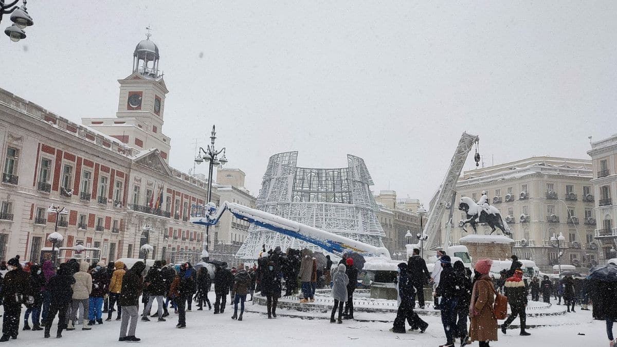 Puerta del Sol nevada en Madrid con varias personas observando el paisaje invernal