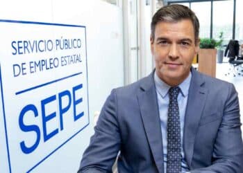 Pedro Sánchez frente a un cartel del Servicio Público de Empleo Estatal (SEPE), representando las novedades en prestaciones y subsidios para mayores de 52 años en 2025.