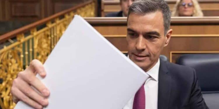 Pedro Sánchez sosteniendo un documento con el Plan de Ayudas a Familias 2025 en el Parlamento