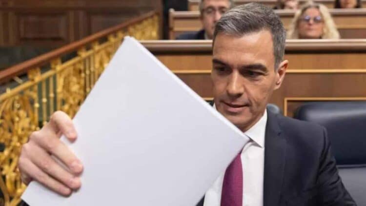 Pedro Sánchez sosteniendo un documento con el Plan de Ayudas a Familias 2025 en el Parlamento