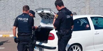 Policía local ojea un maletero de un vehículo.