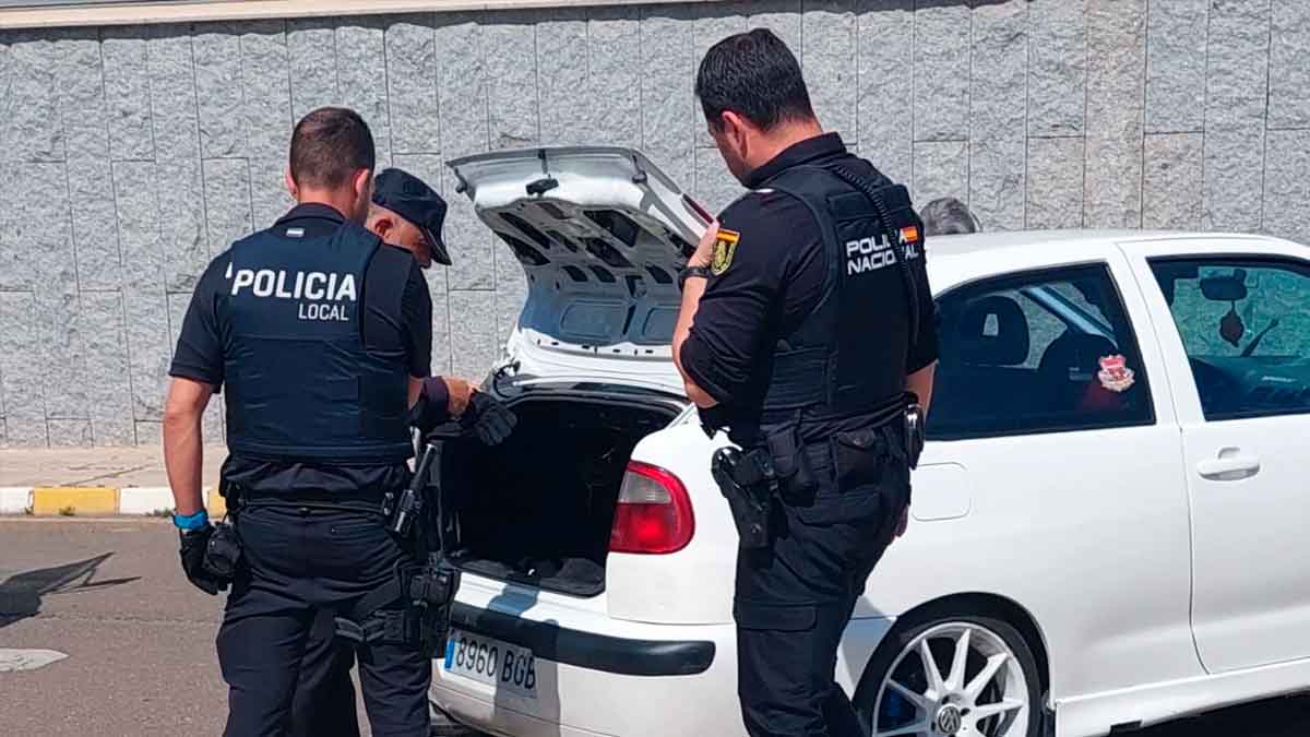 Policía local ojea un maletero de un vehículo.