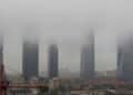 Vista de las Cuatro Torres de Madrid envueltas en niebla y cielo gris