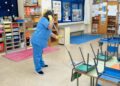 Auxiliar de limpieza realizando tareas en un aula de colegio en Alcalá de Henares, Madrid.