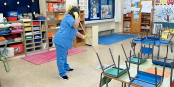 Auxiliar de limpieza realizando tareas en un aula de colegio en Alcalá de Henares, Madrid.