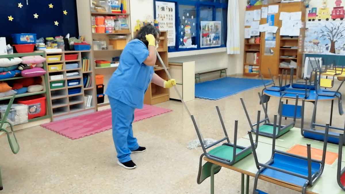 Auxiliar de limpieza realizando tareas en un aula de colegio en Alcalá de Henares, Madrid.