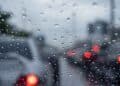 Parabrisas con gotas de lluvia y luces de vehículos difuminadas en Madrid durante un tren de borrascas