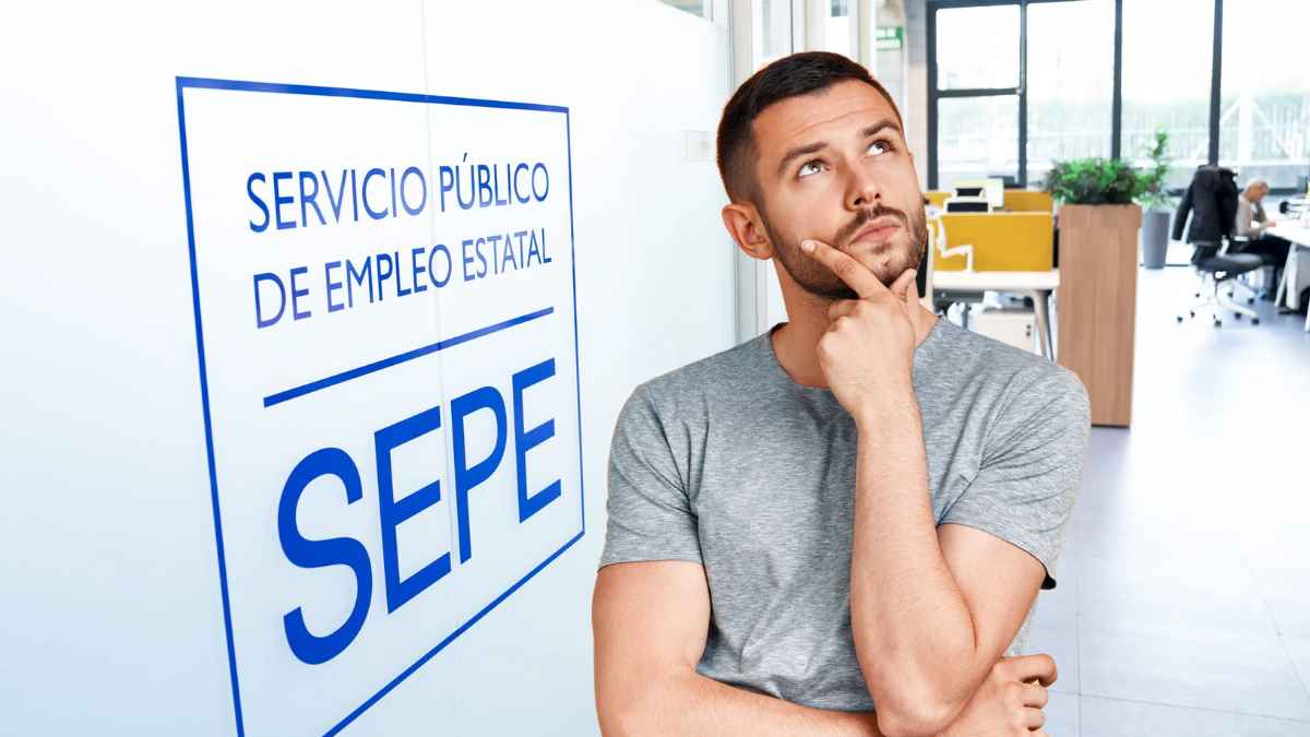 Hombre pensativo frente a oficina del SEPE sobre prestaciones por desempleo