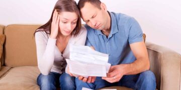Pareja preocupada revisa documentos por riesgo de perder el Ingreso Mínimo Vital en 2025 tras no cumplir obligaciones fiscales