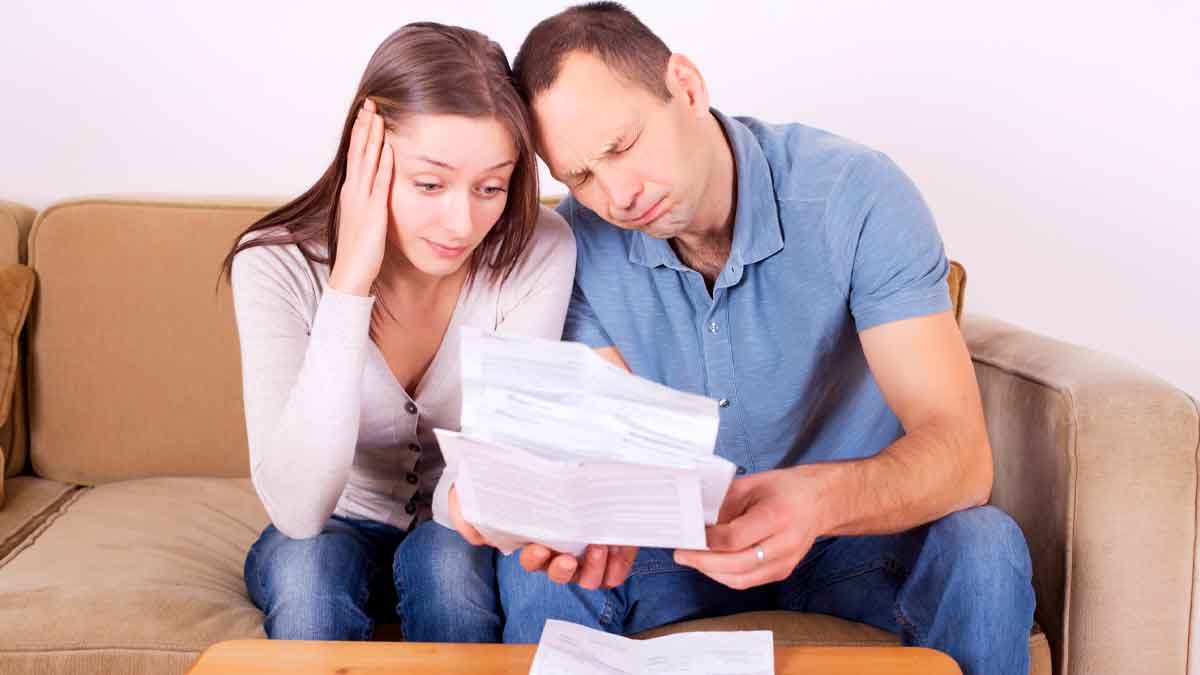 Pareja preocupada revisa documentos por riesgo de perder el Ingreso Mínimo Vital en 2025 tras no cumplir obligaciones fiscales
