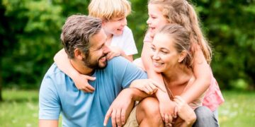 Familia con dos hijos disfrutando al aire libre, ejemplo de beneficiarios de la deducción de 300 y 900 euros de Hacienda
