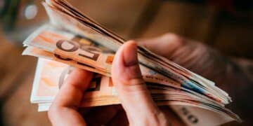 Contando billetes de euro, símbolo de las nuevas ayudas del SEPE para desempleados con ingresos menores de 900 euros mensuales