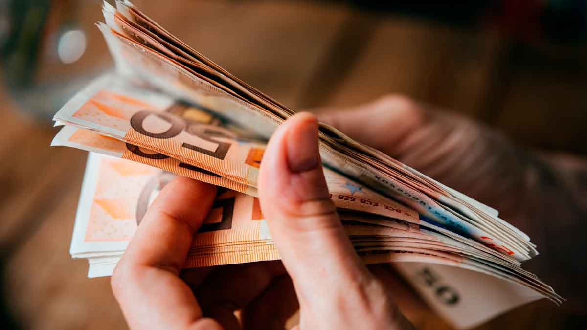 Contando billetes de euro, símbolo de las nuevas ayudas del SEPE para desempleados con ingresos menores de 900 euros mensuales
