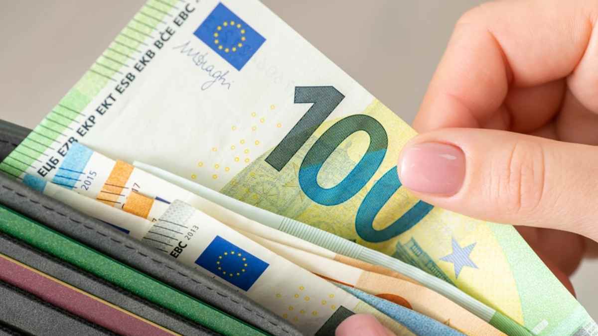 Mano sosteniendo billetes de euro en una cartera para ilustrar la promoción de hasta 750 euros de un banco digital sin comisiones