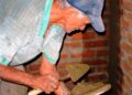 Hombre mayor trabajando como albañil tras la edad de jubilación, compatibilizando empleo y pensión
