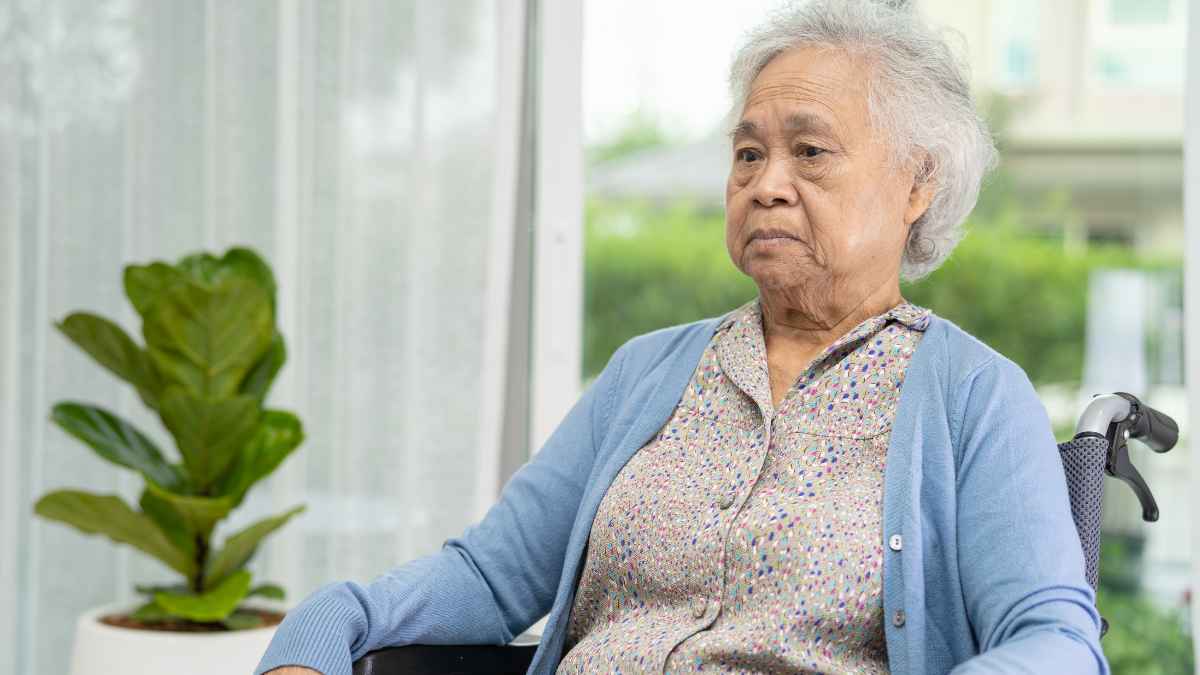 Mujer mayor sentada en silla de ruedas en una residencia, representando solicitud de dependencia en Madrid