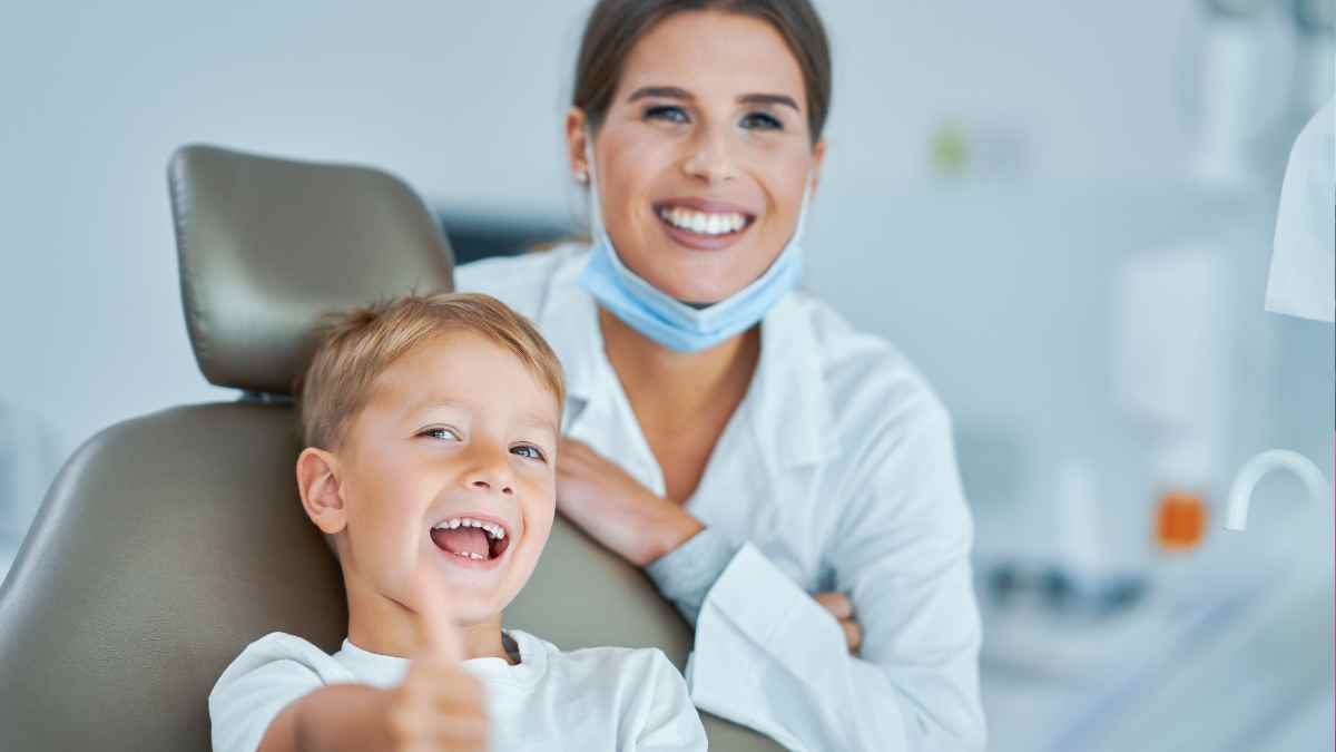Niño sonriente con dentista en consulta dental, programa gratuito de empastes y limpiezas