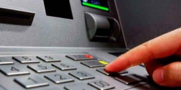 Dedo presionando el botón “Cancelar” de un cajero automático para cerrar sesión y prevenir fraudes y estafas bancarias