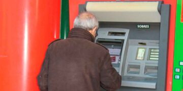 Pensionista retirando dinero en un cajero automático; días de cobro de las pensiones de abril 2025