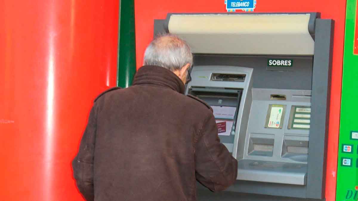 Pensionista retirando dinero en un cajero automático; días de cobro de las pensiones de abril 2025