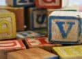 Bloques de madera con letras de colores, destacando la letra V, para ilustrar la importancia de diferenciar la B de la V