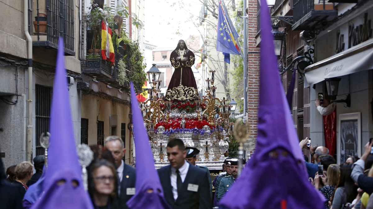 Procesión de Semana Santa en Madrid con nazarenos y paso de la Virgen en una calle del centro histórico