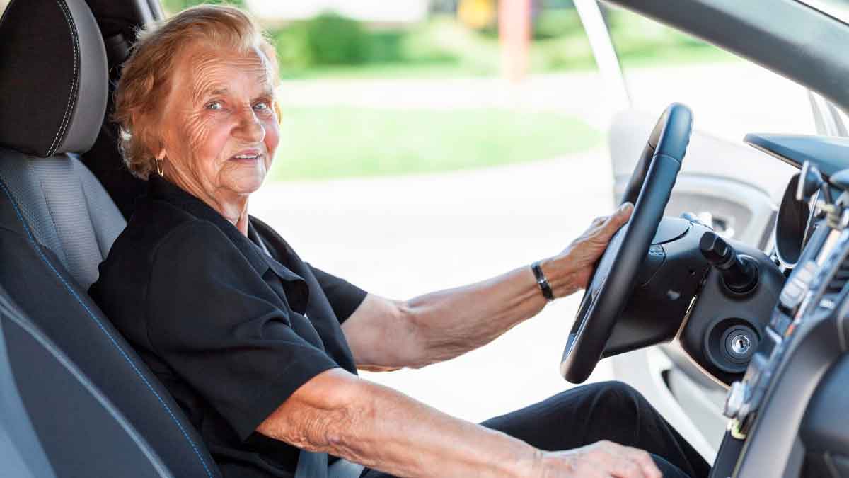 Mujer mayor conduciendo un coche, normativa DGT renovación carnet mayores de 65