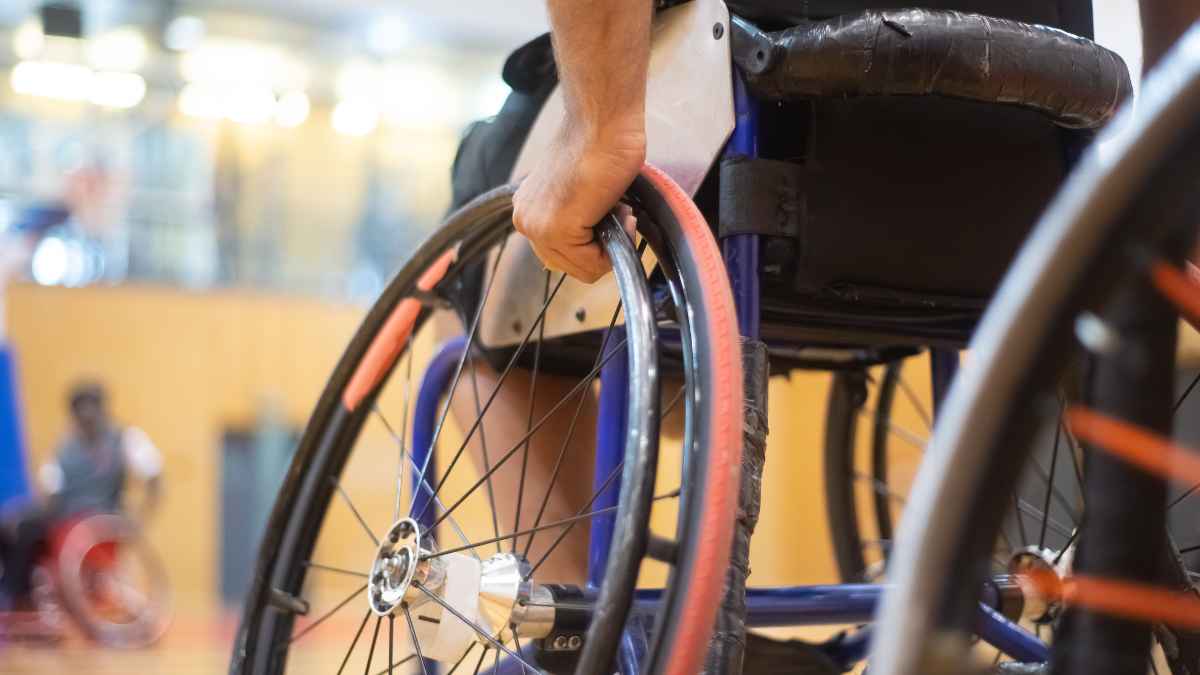 Persona en silla de ruedas en primer plano, simbolizando la incapacidad permanente y los cambios en las revisiones médicas