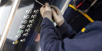 Técnico revisando panel interior de ascensor para cumplir nueva normativa de seguridad vigente desde julio