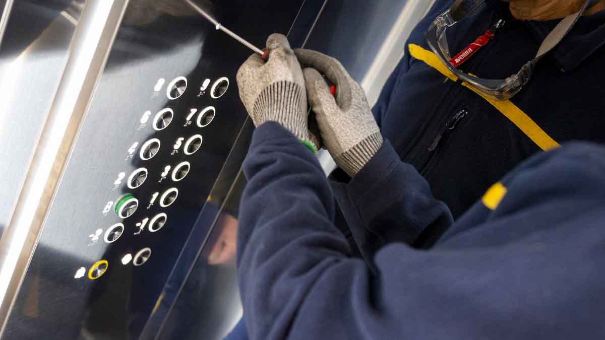Técnico revisando panel interior de ascensor para cumplir nueva normativa de seguridad vigente desde julio