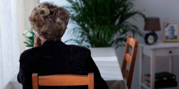 Mujer mayor de espaldas, sola en casa tras perder a su cónyuge; ejemplo real de beneficiaria de la pensión de viudedad de la Seguridad Social