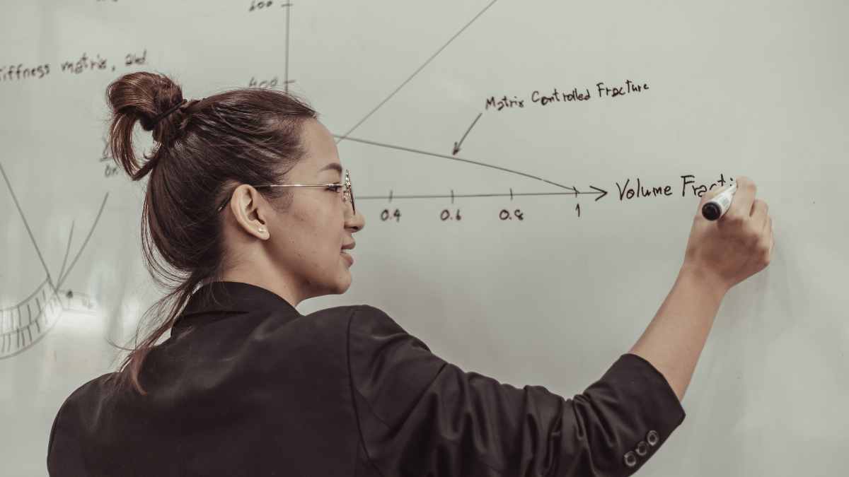 Profesora de Secundaria escribiendo en la pizarra durante su jornada lectiva en Madrid.
