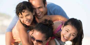 Padre, madre y dos hijas sonriendo mientras disfrutan de un momento familiar