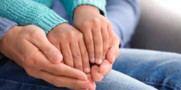 Manos de un adulto sosteniendo las de un niño, símbolo de la adopción en la Comunidad de Madrid 2025
