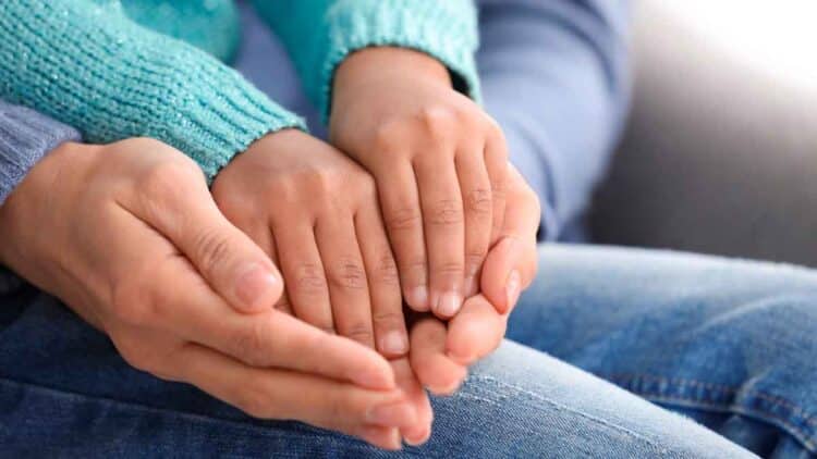 Manos de un adulto sosteniendo las de un niño, símbolo de la adopción en la Comunidad de Madrid 2025
