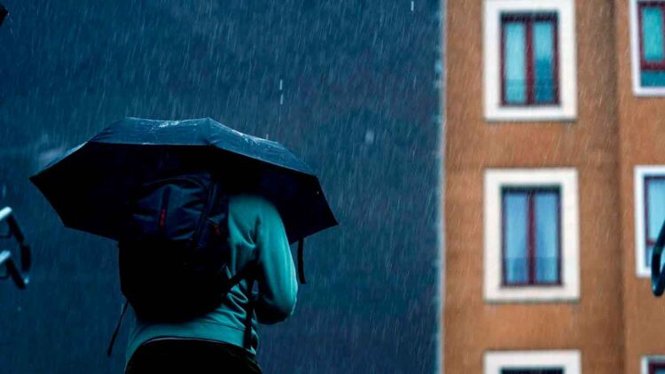 Persona con paraguas bajo lluvia intensa en Madrid, según previsión de la AEMET para el fin de semana