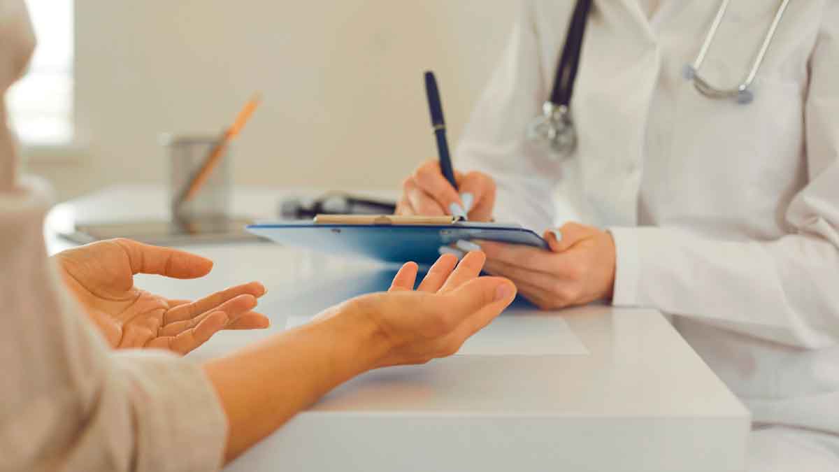 Persona hablando con un médico sobre su baja laboral por incapacidad temporal