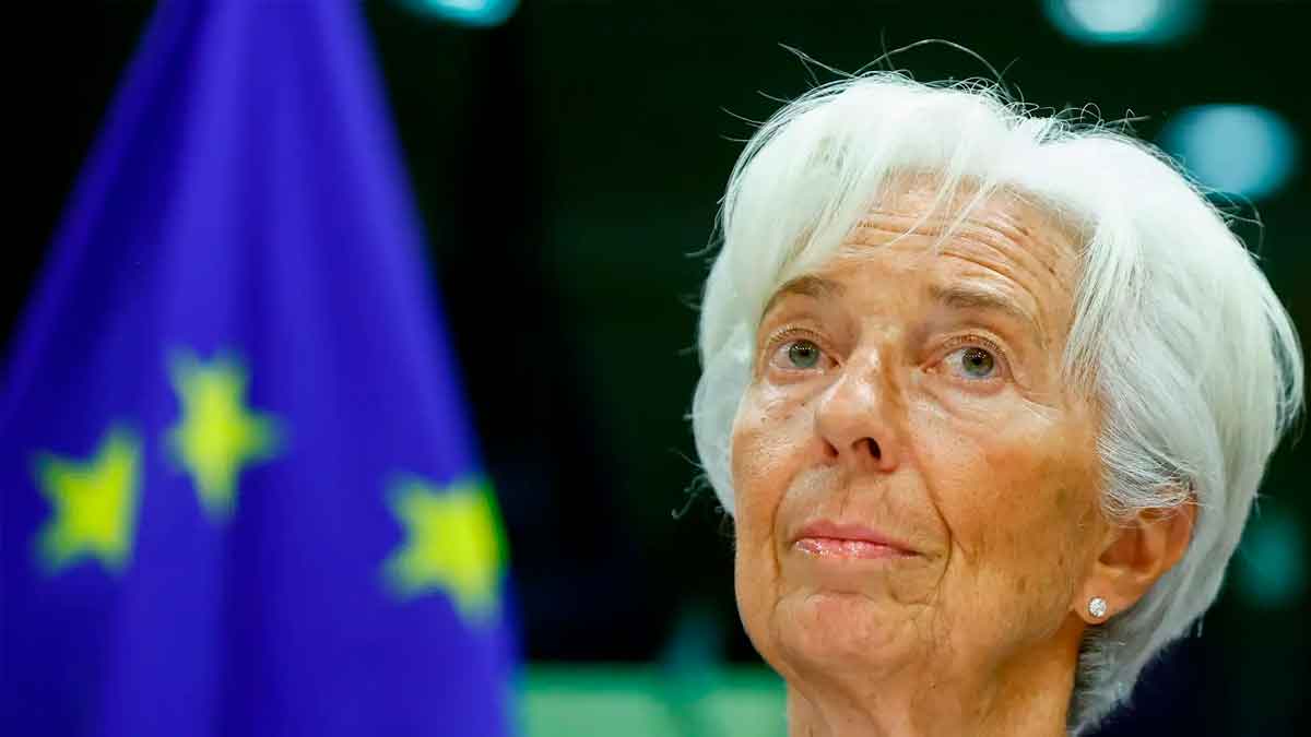 Primer plano de una alta funcionaria del Banco Central Europeo ante la bandera de la UE durante el anuncio de una próxima bajada de tipos de interés