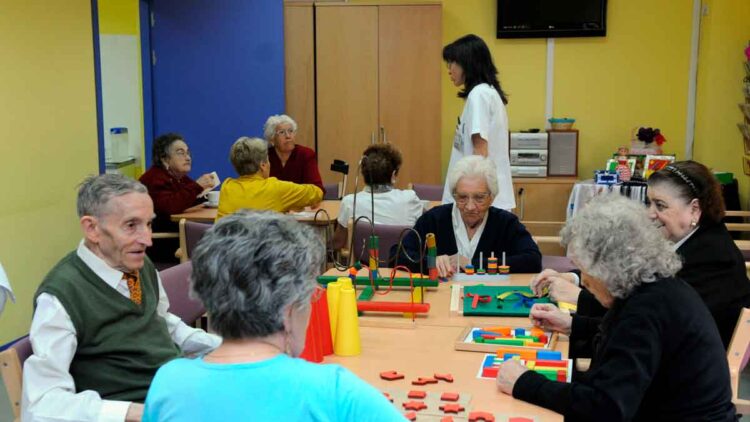 Personas mayores disfrutan de juegos de estimulación en un centro de mayores de la Comunidad de Madrid, accesible con el carné gratuito de usuario
