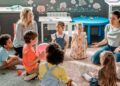 Niños y educadoras sentados en círculo en una escuela infantil privada de Madrid, ejemplo del Cheque Guardería 2025-2026
