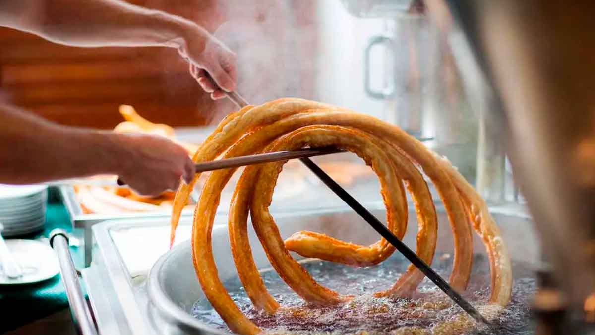 Churrero de Marbella elaborando una gran rueda de churros en aceite, implicado en el robo de 86 000 euros con un truco de caja