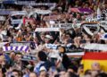 Aficionados del Real Madrid levantan bufandas y móviles en el Santiago Bernabéu, ambiente de grada que disfrutan los socios del club