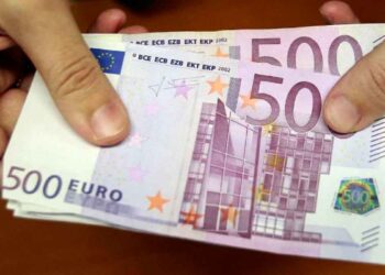 Billetes de 500 € en manos, representando la ayuda de 10.980 € del SEPE para desempleados con cotización insuficiente