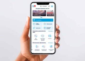 Mano sostiene un móvil con la app Tarjeta Sanitaria Virtual de la Comunidad de Madrid, que mostrará alertas personalizadas de calor extremo